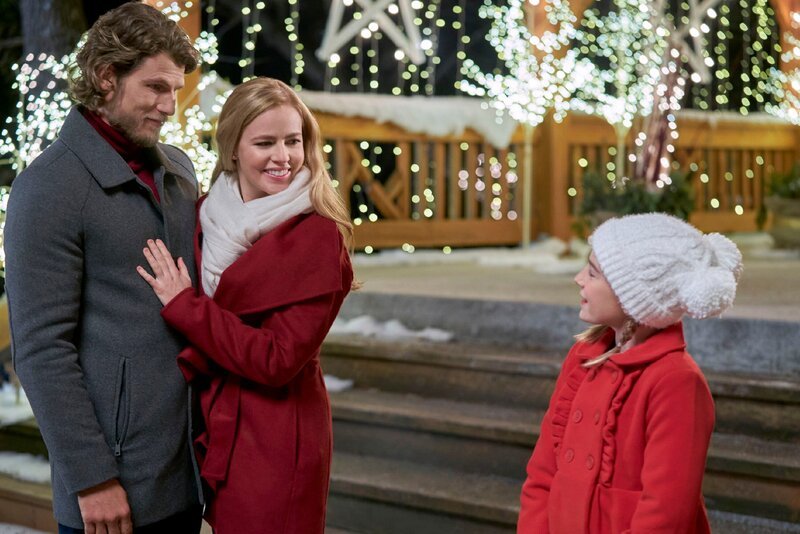 Lucy (mi.) hat es geschafft, mit ihrer Energie und Großherzigkeit dem Leben des Witwers Lucas (li.) und seiner Tochter Max (re.) wieder Glück und Weihnachtsmagie einzuhauchen und Max ihren Weihnachtswunsch zu erfüllen. Während sie der Erfüllung dieses Wunsches nachgeht, erfüllt sie sich unerwartet auch ihre eigenen Wünsche. Lucas und Lucy finden zueinander und werden ein glückliches Paar. – Bild: Crown Media