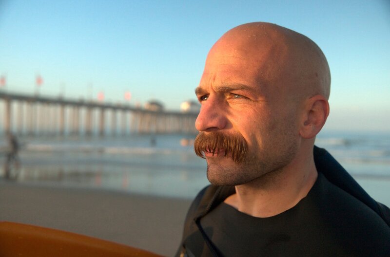 Der konservative Surfer Charlie ist tief religiös und verehrte Charlie Kirk. Er hat zwar Trump gewählt, aber als Christ stößt ihn das Spaltende des Präsidenten ab. Für ihn ist es am wichtigsten, seine Kinder vor der liberalen Gesellschaftspolitik der Demokraten zu schützen. – Bild: NDR