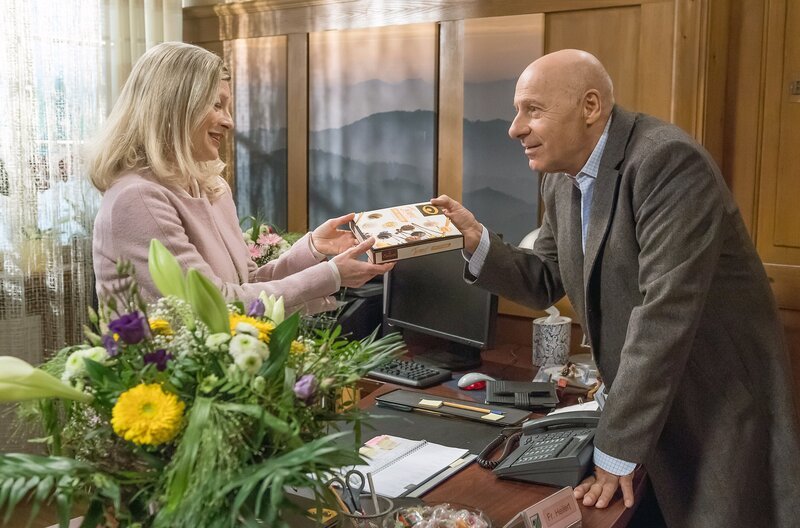 Franz Faller (Edgar-M. Marcus) bringt Claudia Heilert (Adelheid Theil, li.) Pralinen mit … so ganz ohne Absicht? – Bild: SWR/​Alexander Kluge