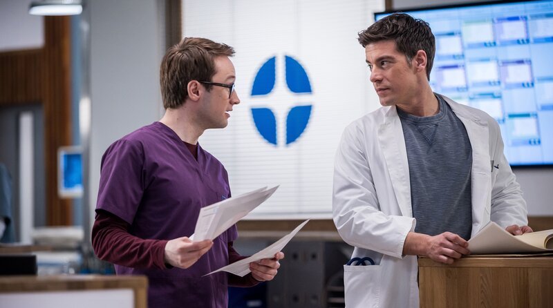 Oliver Probst (Arne Kertész, l.) widmet sich dem medizinisch rästelhaften Fall, den er von Dr. Ben Ahlbeck (Philipp Danne) vorgelegt bekommen hat. – Bild: ARD/​Michael Kremer
