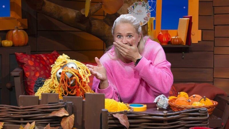 Singa und Rudi basteln im Baumhaus Deko-Kürbisse mit Wolle. Rudi verheddert sich und ist plötzlich komplett in Wolle gewickelt. – Bild: KiKA