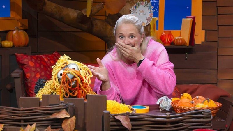 Singa und Rudi basteln im Baumhaus Deko-Kürbisse mit Wolle. Rudi verheddert sich und ist plötzlich komplett in Wolle gewickelt. – Bild: KiKA