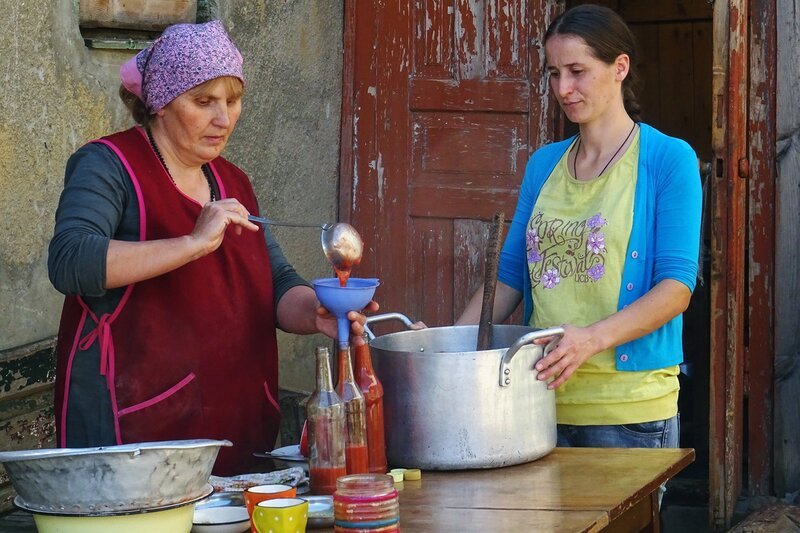 Zu Tisch Swanetien – Georgien: Lilly Tamliani und Schwiegertochter Khatia füllen den georgischen Ketchup aus gekochten Pflaumen ab. – Bild: SRF/​Berlin Producers/​Gerd Müller