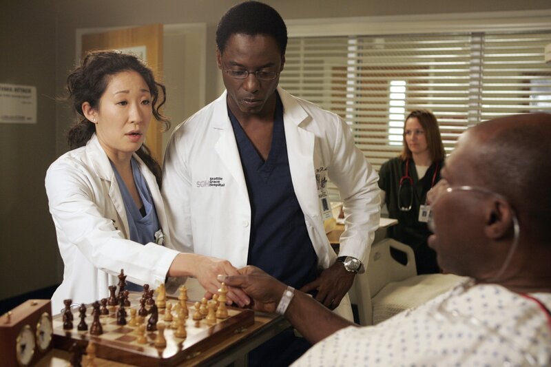 Cristina (Sandra Oh, l.) hat einen Weg gefunden, Colin zu verschrecken, indem sie vor Charles (Brent Jennings, r.), dem Patienten, dem Colin ein neues Herz transplantieren wird, von ihrer bevorstehenden Hochzeit mit Burke (Isaiah Washington, 2.v.l.) schwärmt … – Bild: 2007 American Broadcasting Companies, Inc. All rights reserved. NO ARCHIVE. NO RESALE. /​ Vivian Zink Lizenzbild frei