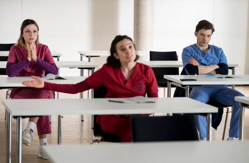 Viktoria Stadler (Isabella Krieger, l.) und Florian Osterwald (Lion Wasczyk, r.) bekommen mit, wie Rebecca Krieger (Milena Straube, M.) sich beschwert. – Bild: ARD/​Jens-Ulrich Koch