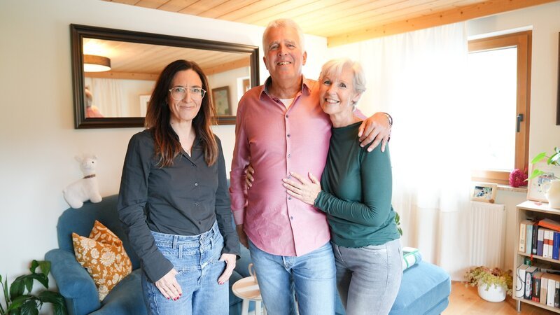 Nina Horowitz (l.) mit Sieglinde und Christian. Sieglinde, 63, Busreiseleiterin i.R. aus Tirol, suchte 2020 einen Mann der „charmant, romantisch, groß und jünger“ sein sollte. Bekommen hat sie ihren Christian. „Ich bin kein Tiroler, ich bin ein Bayer. Aber wir verstehen uns auch so“, lacht er heute. Als Christian Sieglinde damals im Fernsehen sah, war’s um ihn geschehen. „Ich hab sofort einen Freund angerufen und gesagt: Schau dir die Sieglinde an, die heirate ich einmal!“ Und er sollte recht behalten: Im Februar 2022 läuteten die Hochzeitsglocken und seitdem sind die beiden unzertrennlich. Dabei war Sieglinde heiß begehrt, über 250 Zuschriften hat sie bekommen. Kurz war sie mit einem anderen Mann zusammen, mit dem die Beziehung in die Brüche ging. Sie beschloss danach, noch einen Versuch zu wagen. „Ich hatte alle Briefe weggeschmissen – bis auf einen einzigen. Und das war dann der Christian“, erzählt sie mit einem breiten Lächeln. Das erste Treffen mit ihrem heutigen Mann ließ nicht lange auf sich warten. „Ich kam mit dem Zug an, schaute aus dem Fenster und mein Herz und Kopf haben gleichzeitig einen Polterer gemacht. Ich wusste sofort: Das ist er!“, erinnert sich Sieglinde. Nach einiger Zeit verließ Christian seine bayerische Heimat und zog zu ihr nach Tirol. „Die Liebe zu Sieglinde war stärker als die Heimatliebe“, sagt er überzeugt. Und die Gefühle? So tief wie am ersten Tag: „So eine Liebe wie zu Sieglinde hab ich noch nie erlebt. Es war so schnell klar, dass sie die Richtige ist.“ Da strahlt Sieglinde über beide Ohren: „Ich hab schon Tränen in den Augen!“ Und für sie steht fest: „Es war Schicksal, dass wir uns über die ‚Liebesg‘schichten’ gefunden haben. Ich kann nur allen raten – macht’s mit bei der Sendung und nutzt eure Chance!“ – Bild: Talk TV /​ ORF /​ Wout Kichler