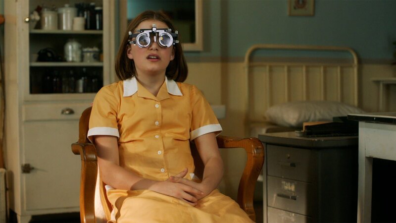 Darrell (Ella Bright) muss sich einem Sehtest unterziehen. Ihre Lehrerinnen wollen herausfinden, ob Darrells schlechte Rechtschreibung wohlmöglich durch eine Sehschwäche verursacht wird. – Bild: ZDF/​ DHX – Malory Productions Inc./​Queen Bert Productions