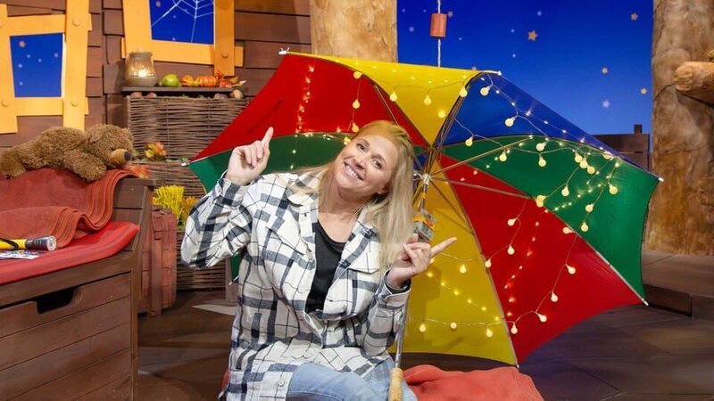 Singa macht es sich im Baumhaus gemütlich. Mit einem Regenschirm und Lichterketten baut sie sich eine kuschelige Herbstbude. – Bild: KiKA