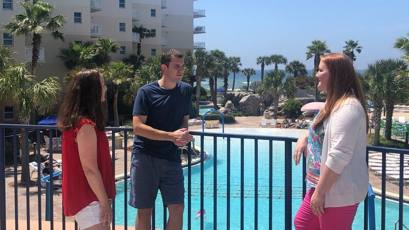 Contributors Ashley Hughes (L) and Brandon Hughes (C) chat with real estate agent Callan Edick (R) by the beautiful pool area at Destin West as seen on HGTV’s Beachfront Bargain Hunt. – Bild: HGTV /​ Scripps (Focus)