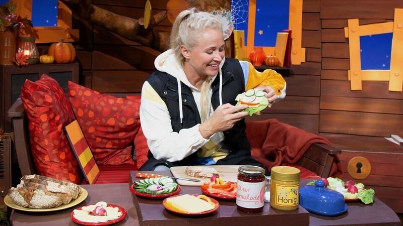Singa zeigt wie sie abends ihr Brot belegt. Das erinnert sie an eine Figur bei KiKA, weißt du welche? – Bild: KiKA