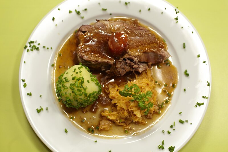 Schweinsbraten mit Bratensauce, Kartoffelknödeln und saures Rahmkraut. – Bild: ORF 1