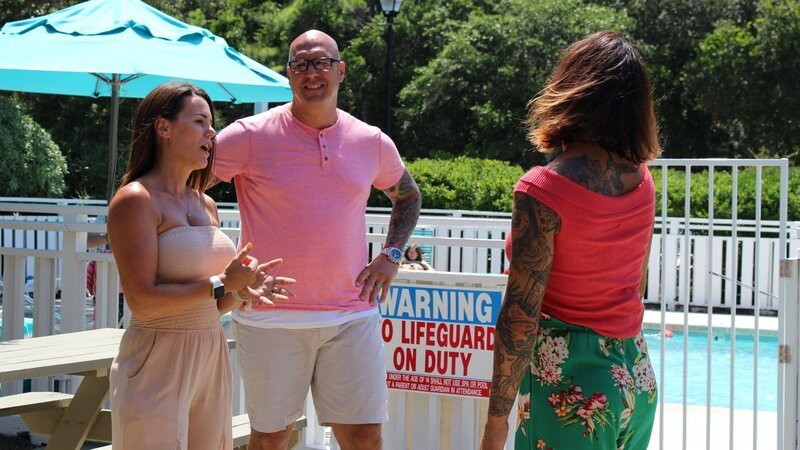 Contributors Cory Ellis (L) and Lary Ellis (C) chat with real estate agent Michele Schaack (R) by the pool at Ocean Dunes before touring the condo as seen on HGTV’s Beachfront Bargain Hunt. – Bild: Discovery, Inc.