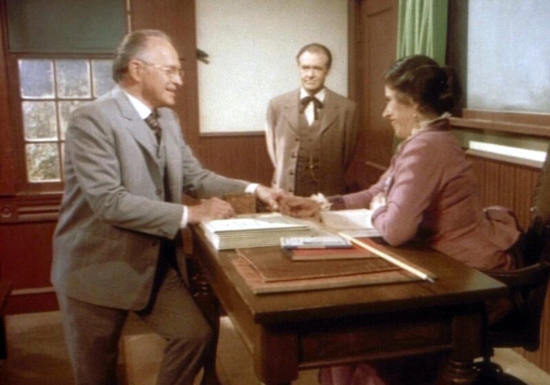 Mr. Stohler (Walker Edmiston, l.) gratuliert Mrs. Oleson (Katherine McGregor, r.) zu ihrem Unterrichtserfolg. Doch Mr. Oleson (Richard Bull, M.) ist der Meinung, dass Farmerskinder nicht unbedingt Französsch lernen müssen. – Bild: Sat.1 Gold