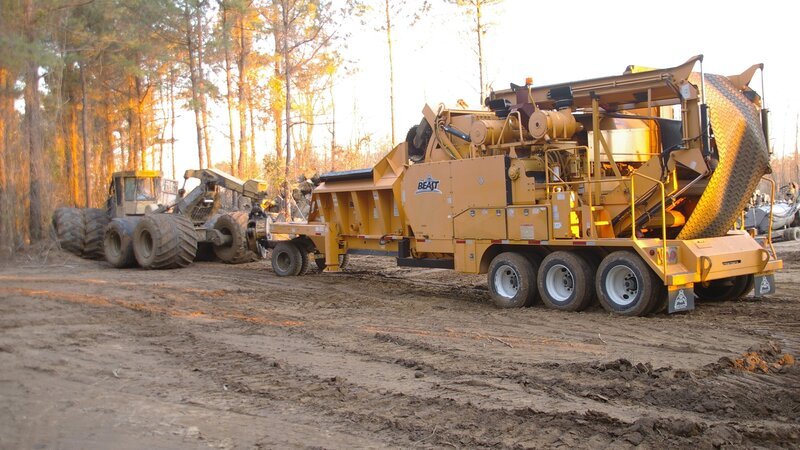 Skidder dropping wood off at the powerful grinder. – Bild: Discovery Channel
