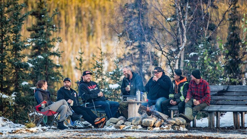 Die Crew von Rick Ness (3.v.l.) saß bei der letzten Goldwägung um die Feuerstelle herum – Bild: Warner Bros. Discovery, Inc. or its subsidiaries and affiliates. All rights reserved.