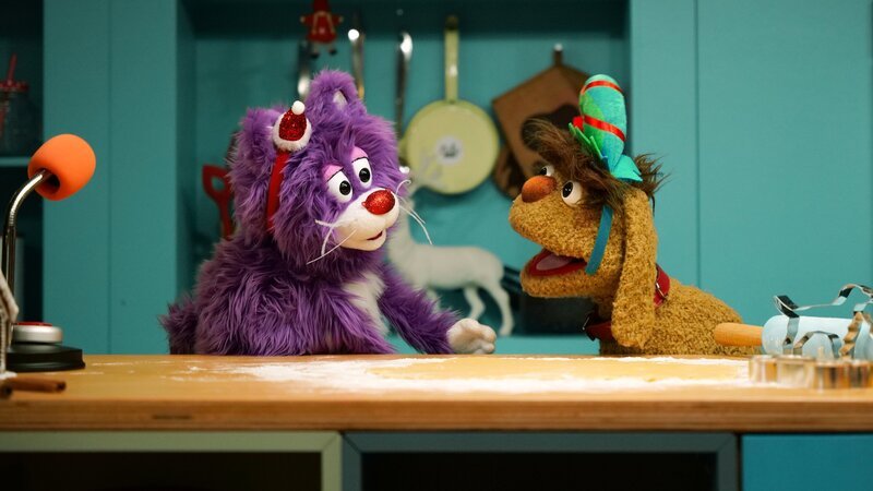 MiWau und Moppi sind festlich gekleidet und stechen gemeinsam Plätzchen aus. – Bild: rbb/​Anderthalb