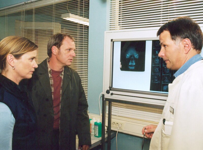 Dr. Heilmann (Thomas Rühmann, rechts) braucht von den Eltern (Karina Fallenstein, Herbert Trattnig) einer Patientin die Einverständnis, sofort operieren zu können. – Bild: MDR/​Krajewski