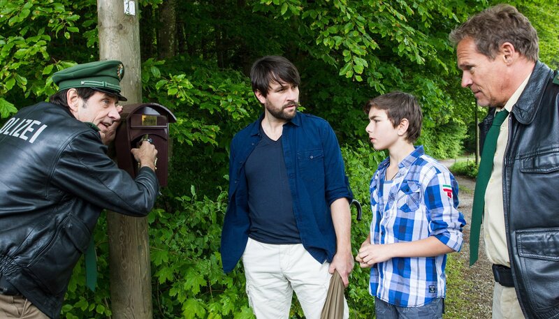 ARD HEITER BIS TÖDLICH – HUBERT UND STALLER, III. Staffel, Folge 33 (Wh.), „Der Tod hat 1000 Stacheln“, am Mittwoch (13.05.15) um 18:50 Uhr im Ersten. Staller inspiziert ein an einem Holzpfosten befestigtes Briefkastenhäuschen. Die Klappe ist gewaltsam geöffnet worden. Der Eigentümer Jens Rieger und sein Sohn stehen neben Hubert und Staller und beobachten die Ermittlungen. Im Bild v.l.n.r. Staller (Helmfried von Lüttichau), Jens Rieger (Stefan Evertz), Roman Rieger (Shayan Hartmann), Hubert (Christian Tramitz) – Bild: ARD/​TMG/​Chris Hirschhäuser
