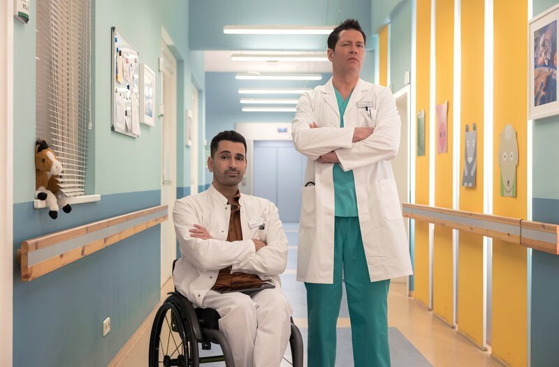 Dr. Philipp Brentano (Thomas Koch, re.) und Dr. Ilay Demir (Tan Caglar, li.) beobachten eine Kollegin und trauen ihren Augen nicht. – Bild: MDR/​Saxonia Media/​Rudolf Wernicke