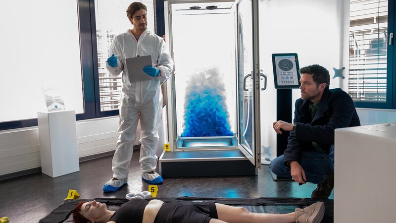 Ein Studio für Kältetherapie wird zum Tatort: Die Geschäftsführerin Barbara Döring (Yvy Heußler, M.) wurde absichtlich in eine Kältekammer eingeschlossen und ist dort erfroren. Das berichtet Rechtsmediziner Dr. Benedikt Förster (Florian Wünsche, l.) dem Kriminalkommissar Jo Stoll (Peter Ketnath, r.). Wer hatte Grund zu so einer Tat? – Bild: ZDF und MARKUS_FENCHEL
