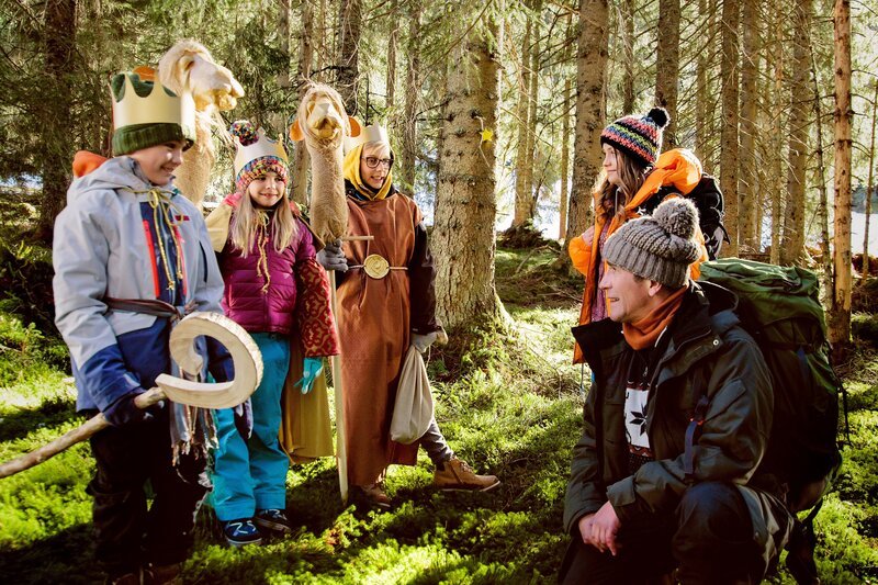 Die Kinder (Emilio Reisinger, l., Cosima Reisinger, 2.v.l., Lukas Lutter, 3.v.l.) zeigen Fritz Fuchs (Guido Hammesfahr, r.) und Charlie (Géraldine Raths, 2.v.r.) den Weg zu Weihnachtsunterkunft in den Bergen. Sie erzählen auch, dass dort oben ein Wichtel haust. – Bild: Andrea Hansen Fotografie