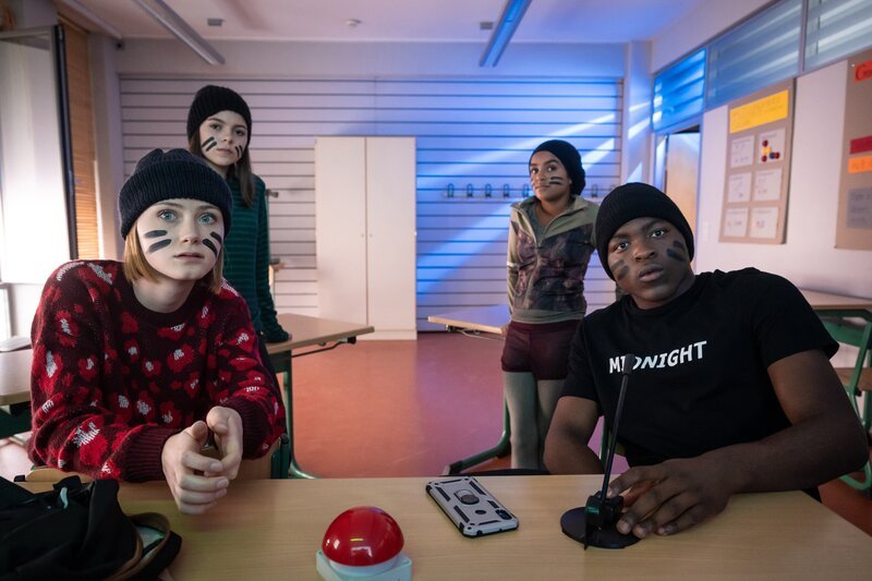 Flora (Carla Hüttermann, vorne links) stellt Rosa (Karlotta Hasselbach, hinten links), Reena (Sophia Leonie Mauritz) und Badu (Arnold Makuissie) vor die „Invisible Challenge“. – Bild: KiKA