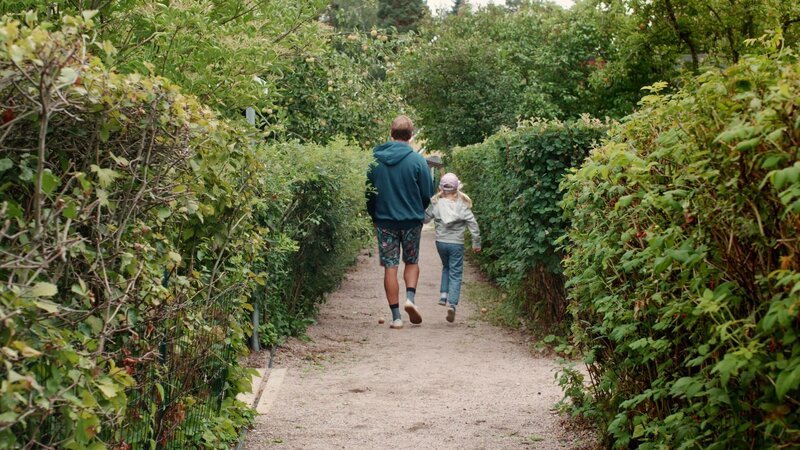Vilda (Sofia Sittnikow) und ihr Papa besuchen Tante Eva in ihrem Schrebergarten. – Bild: KiKA/​Anton Tevajärvi
