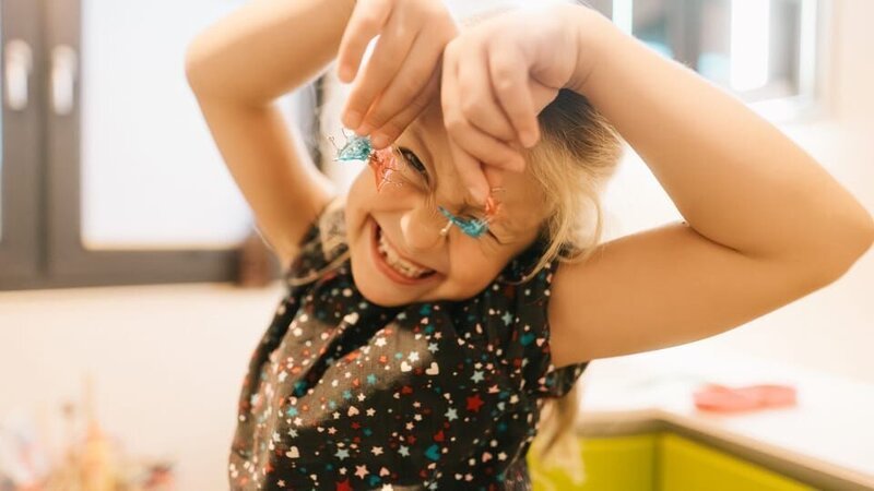 Charlotte hält die Spangen vor ihre Augen. – Bild: KiKA/​Markus Hering