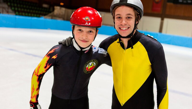 In einem großen Checker-Experiment testet Tobi, wie dick das Eis sein muss, damit man drauf darf. Danach wird es rasant: Short Tracker wie Robin erreichen auf dem Eis Geschwindigkeiten über 40 km/​h. Checker Tobi (rechts) mit Shorttracker Robin Tenzer. – Bild: BR/​megaherz gmbh/​Hans-Florian Hopfner