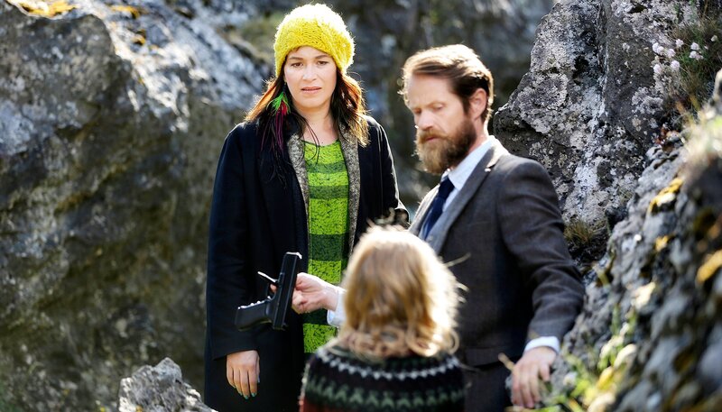 Solveig (Franka Potente) und ihr Kollege Finsen (Joi Johannsson) entdecken die kleine Yrsa (Carlotta von Falkenhayn) mit einer Waffe. – Bild: ARD Degeto/​NDF/​Frank Lübke