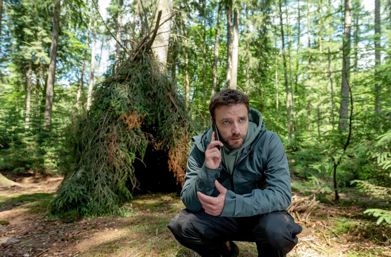 Gregor (Jonas Minthe) hat einen Bushcraft-Shelter, einen Unterschlupf für Survivalbegeisterte, entdeckt. – Bild: ARD/​Thorsten Jander