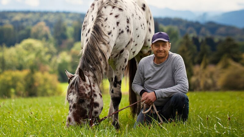 Eine kunterbunte Gemeinschaft: 16 Menschen zwischen 7 und 60 Jahren leben in Vorderhaslach gemeinsam ihre Lust aufs Land. Gründer und Altbauer ist Uwe Neukamm (links). Nahe dem oberbayerischen Tegernsee hat Landwirt Andi Reiter seine Liebe zu amerikanischen Appaloosa-Pferden entdeckt. – Bild: BR/​cutflow GmbH/​isarflimmern fernsehproduktion GmbH/​Matthias Kraus