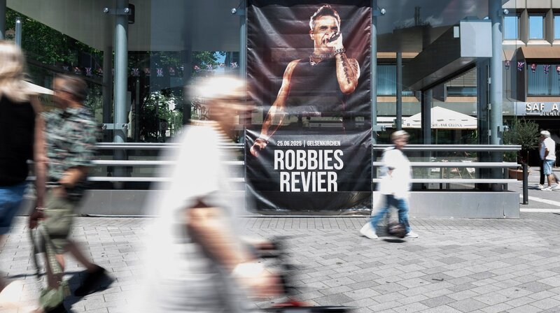Film von Maja Peters, erzählt von Sabine Heinrich. Thema u.a.: Konzert mit Robbie Williams in Gelsenkirchen. (Archivfoto, Plakat in der Innenstadt) – Bild: WDR/​dpa