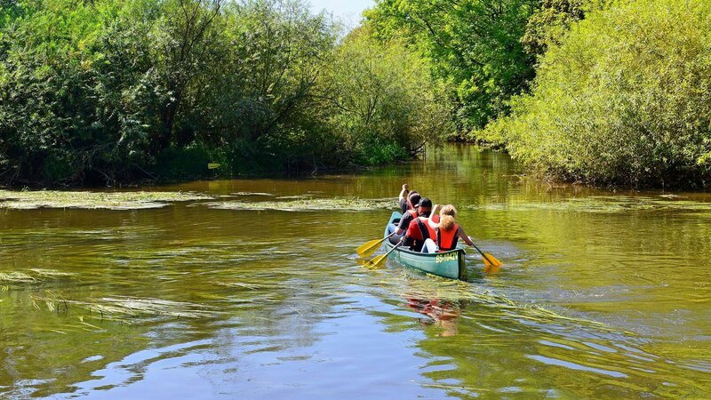 Paddelnde Freizeitsportler spiegeln sich im Wasser des Flusses Leine mitten in der Großstadt Hannover. – Bild: Michael Narten/​picture alliance