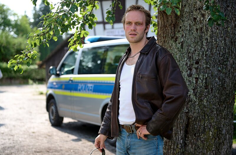 Marko Rackwitz (Felix Kruttke) wartet, während die Kriminaltechnik Erdproben nimmt. – Bild: ARD/​Laurent Trümper