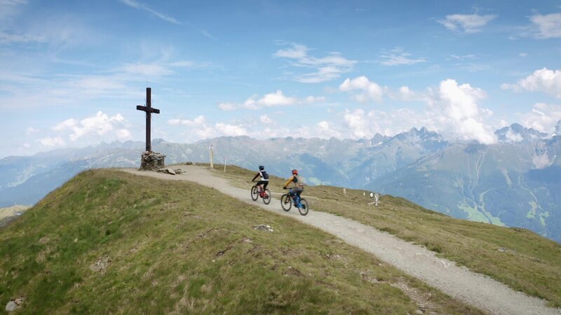 Zwei Personen fahren auf einem Fahrrad. – Bild: Bergblick