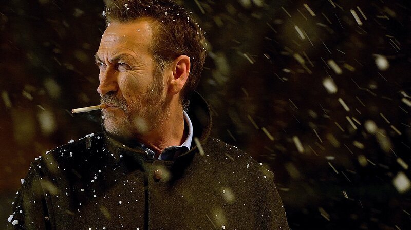 Der Kommissar Rocco Schiavone (Mario Giallini), mit der unvermeidlichen Zigarette, im Rang eines Vice-Questore, ist nicht das, was man unter einem vorbildlichen Polizisten versteht. Er ist nicht nur launisch und zynisch, er nimmt es auch mit dem Gesetz nicht allzu genau. Aus disziplinarischen Gründen wurde der eingefleischte Römer in die italienischen Alpen versetzt – ins Aostatal. – Bild: ARD Degeto