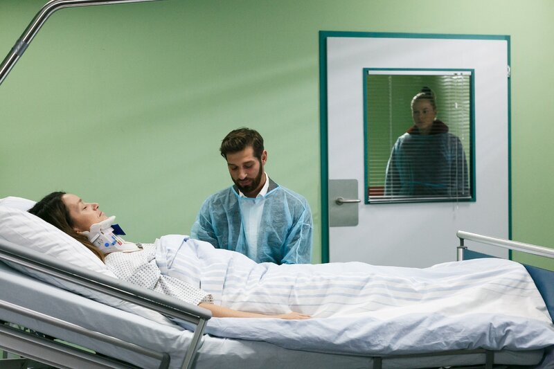 Deniz (Igor Dolgatschew) weicht voller Mitgefühl nicht von Jennys (Kaja Schmidt-Tychsen) Seite, während Marie (Cheyenne Pahde, hinten) ihn beobachtet. – Bild: RTL /​ Kai Schulz