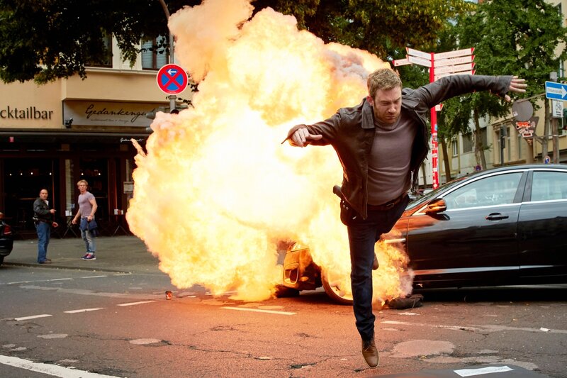 Semir und Paul werden Zeuge, wie ihr Kollege Mario Schleier (Max Engelke) Opfer eines Anschlags wird … – Bild: RTL /​ Guido Engels