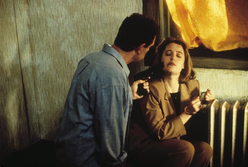 Jack Willis (Christopher Allport, l.) behält Scully (Gillian Anderson, r.) als Geisel und versucht, das FBI um eine Million Dollar zu erpressen. – Bild: ProSieben MAXX