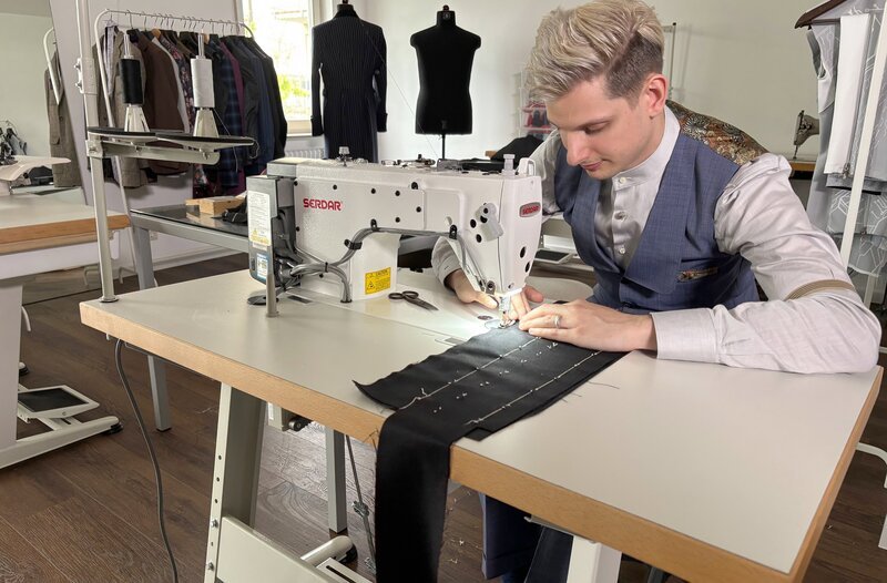 Herrenschneider Dominik Häusler aus Stuttgart vernäht mit Maschine. – Bild: SWR/​Nadja Rangol