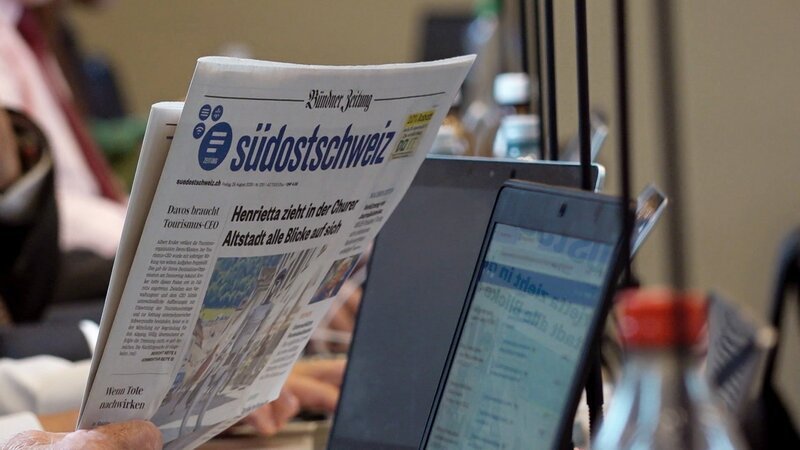 SRF DOK Die letzte Zeitung – Regionaljournalismus auf dem Prüfstand Gedruckte Zeitung „Südostschweiz“ neben einem Notebook – Bild: SRF/​RTR