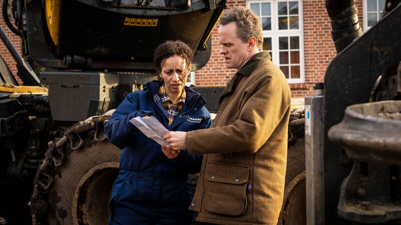 Hermansen (Morten Brovn, rechts) und Tina (Laura Allen Müller) planen, wie sie den Wald roden. – Bild: BR/​TV 2 Denmark, Cosmo Film/​Per Arnesen
