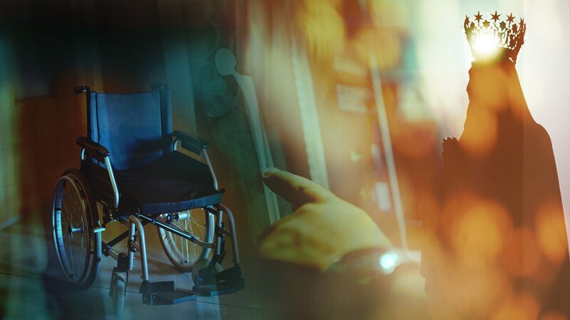 Das Bild zeigt drei Hauptelemente: Links einen leeren Rollstuhl, in der Mitte eine Hand, die auf eine Oberfläche zeigt und rechts eine Figur mit einer Krone. – Bild: SRF
