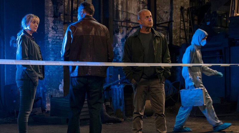 Polizist Rene Clement (Karel Dobrý, Mitte) befragt Max Grosz (Heino Ferch, re.) und Thea Koren (Ingrid Bolsø Berdal) zu dem Leichenfund. – Bild: ARD Degeto/​Odeon Fiction GmbH/​NRK/​Dusan Martincek