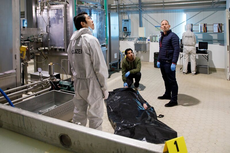 In der Brauerei Kreuzer erklärt Thomas Brandner (Yung Ngo, l.) Samir Amari (Skandar Amini, M.) und Bernhard Henschel (Michael Lott, 2.v.r.), dass die Schädelwunde von Georg Kreuzer (Christian Maria Goebel, 2.v.l.), vermutlich verursacht durch einen Sturz, die Todesursache sein könnte. – Bild: ZDF und Laura Hegewald