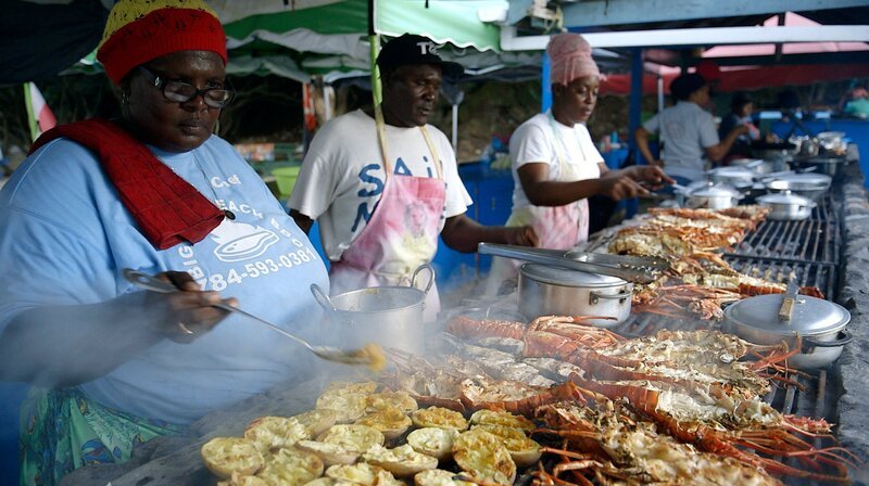An den Stränden der „Tobago Cays“ wird gekocht, gebraten und gebrutzelt. Verschiedene Familien teilen sich einen riesigen Holzkohlegrill und bieten ihre Waren an, vor allem Lobster satt. – Bild: NDR/​nonfictionplanet/​Florian Melzer