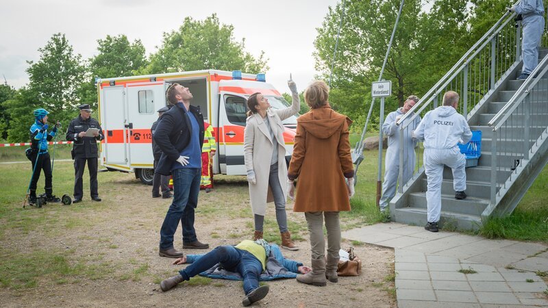 Fenja Wellenmacher (Vanessa Nordhofen, M.), die ein Reinigungsgeschäft besitzt, ist vermutlich vom Aussichtsturm am Bürgerpark geworfen worden. Kommissar Lars Pöhlmann (Dominic Boeer, l.), Kommissarin Joost (Nike Fuhrmann, 2.v.r.) und Rechtsmedizinerin Helene Sturbeck (Katharina Blaschke, r.) stehen vor einem Rätsel: Wer würde so etwas Abscheuliches nur tun? – Bild: ZDF /​ Meyerbroeker