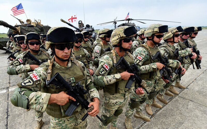 Soldaten nehmen am 1. August 2018 an der gemeinsamen multinationalen Militärübung „Noble Partner 2018“ im Vaziani-Ausbildungszentrum außerhalb von Tiflis teil. – Georgien hat am 1. August 2018 große gemeinsame Militärübungen mit NATO-Streitkräften gestartet – zum 10 seines Krieges mit Russland, das Tiflis Nato-Beitrittsgesuch entschieden ablehnt. An den zweiwöchigen Übungen werden mehr als 3.000 Soldaten aus 13 Ländern teilnehmen, zu denen neben Georgien die Vereinigten Staaten, Frankreich, Deutschland, Großbritannien und die Türkei gehören. – Bild: Getty Images /​ VANO SHLAMOV /​ AFP via Getty Images /​ AFP