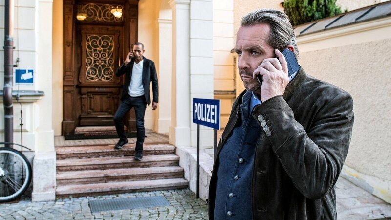 Benedikt Beissl (Andreas Giebel, r.) und Jerry Paulsen (Peter Marton, l.) telefonieren vor der Polizeistation. – Bild: WDR Mediagroup GmbH /​ ARD /​ Susanne Bernhard